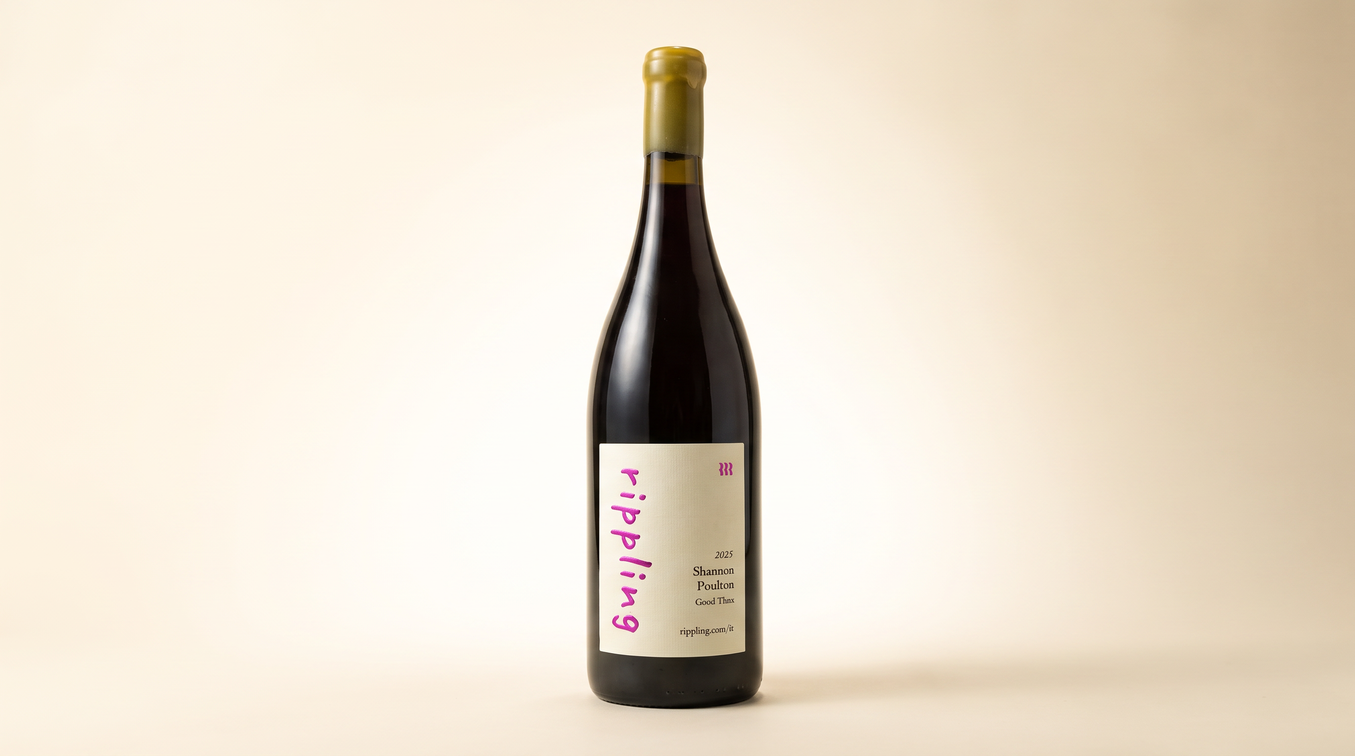 A tailored Melville Estate Pinot Noir wine bottle with the recipient's name printed on the label, on a warm cream studio backdrop with kraft-paper wrapping and cotton string